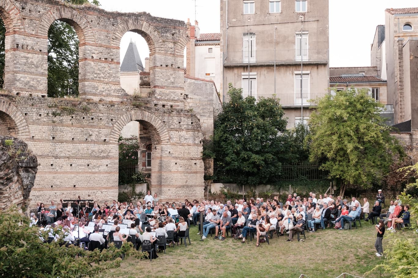 Public devant les arches romaines au coucher du soleil