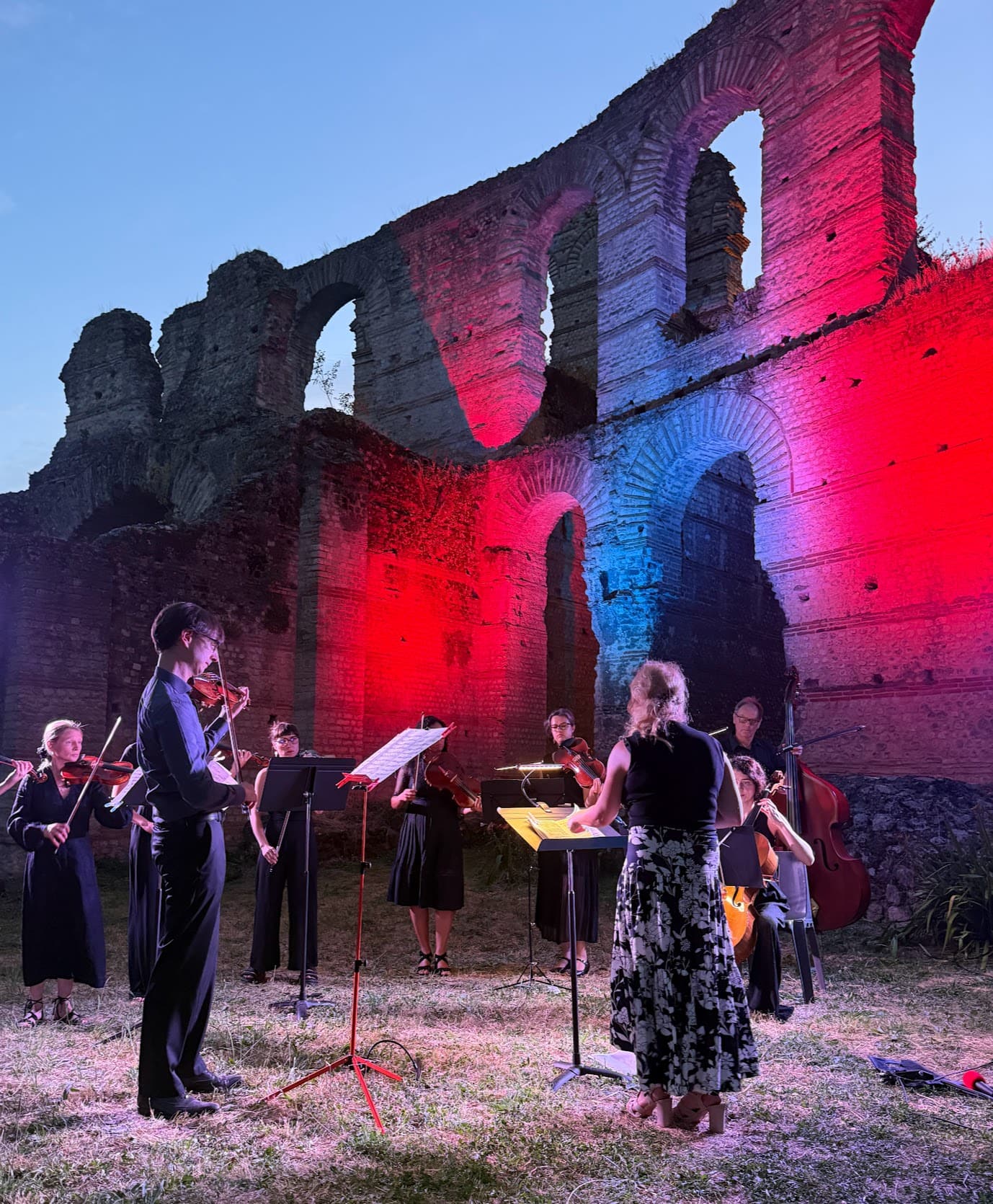 Ensemble jouant devant les ruines illuminées